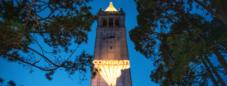 Campanile tower with Congrats projected in lights at dusk.