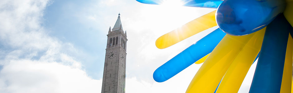 Sather tower in the background, blue and yellow starburst balloons in foreground. Image courtesy Keegan Houser